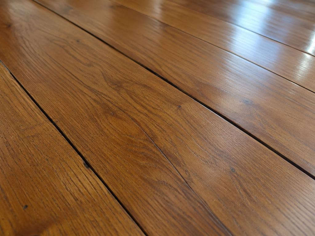 Narrow gaps between hardwood boards that can open when indoor air is very dry during the heating season.